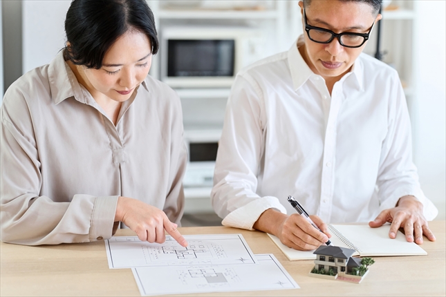 住宅の図面を確認しながら住まいについて話し合うご夫婦